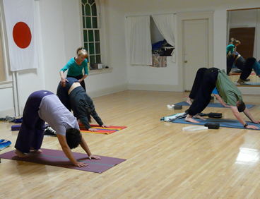 Anita positioning a student in warrior two pose